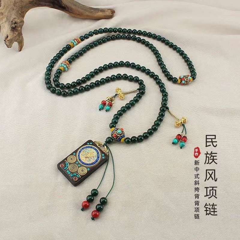 The Legend of Dunhuang necklace with green beads and ornate pendant, inspired by Silk Road dunes, disassembles into two chains.